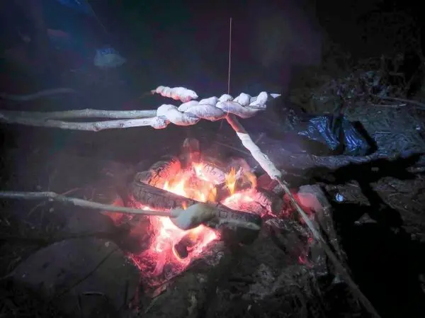 Stöcke mit Teig über einem Feuer zum Rösten