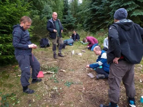Gruppe von Personen übt im Wald mit Ausrüstung und Materialien