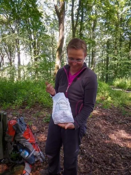 Person hält eine Tüte in der Hand und schaut darauf