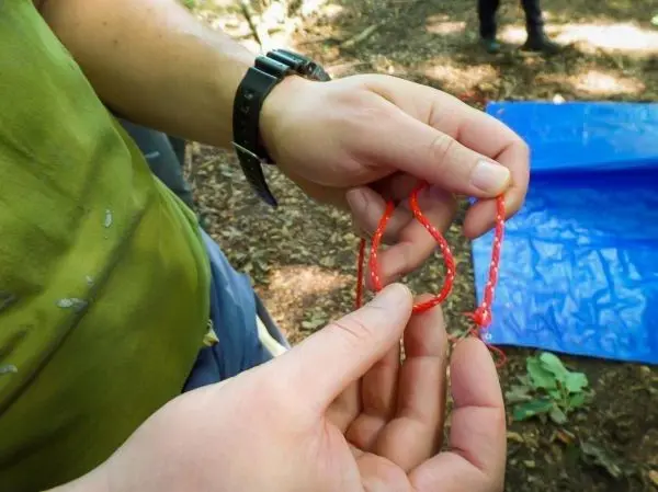 Rote Paracord-Schlingen werden in Händen gehalten