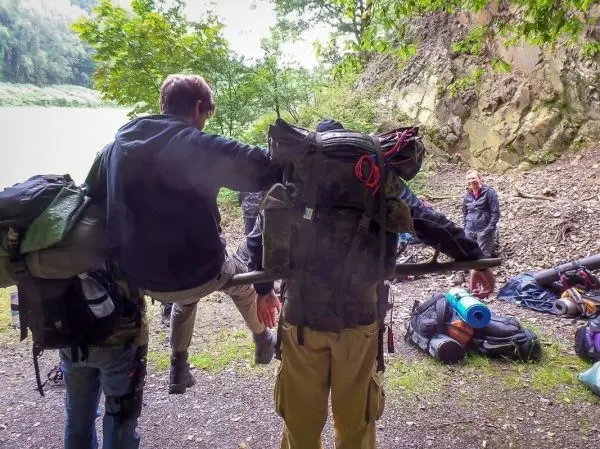 Selbstgebaute Trage transportiert Person über unebenes Gelände