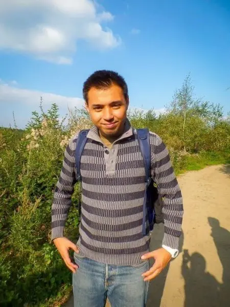 Ein Mann steht auf einem Weg, umgeben von Pflanzen und Bäumen