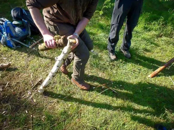 Ein Holzstück wird mit einem Messer bearbeitet