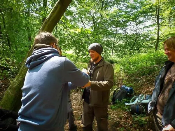 Gruppenaustausch in einem Wald mit Rucksäcken im Hintergrund