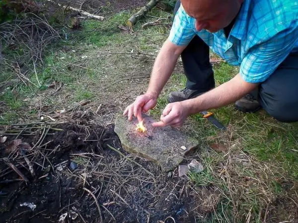 Kleine Flamme auf einem Stein, Zunder wird entzündet