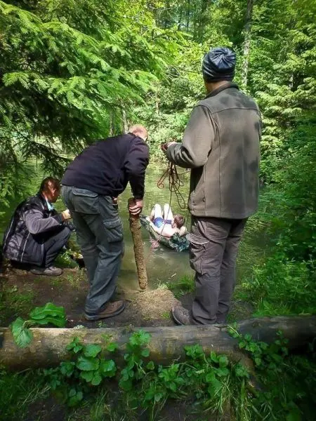 Männer ziehen eine Person mit Seil aus einem Gewässer