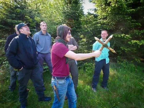 Mann mit zwei Holzstöcken demonstriert eine Technik, um andere zu unterhalten