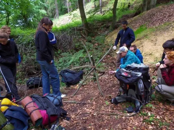 Gruppe arbeitet an einer selbstgebauten Struktur im Wald beim Überlebenstraining