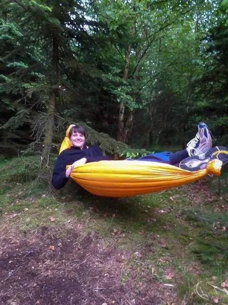 Hängematte zwischen Bäumen mit Person, die entspannt darin liegt