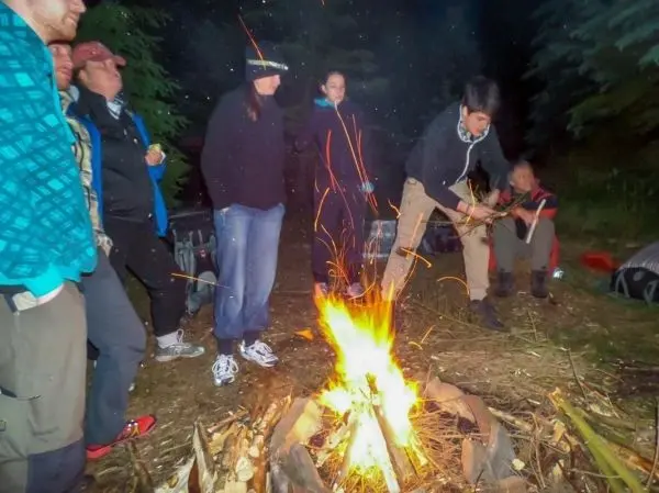 Kleine Flamme lodert im Lagerfeuer, Funken steigen auf