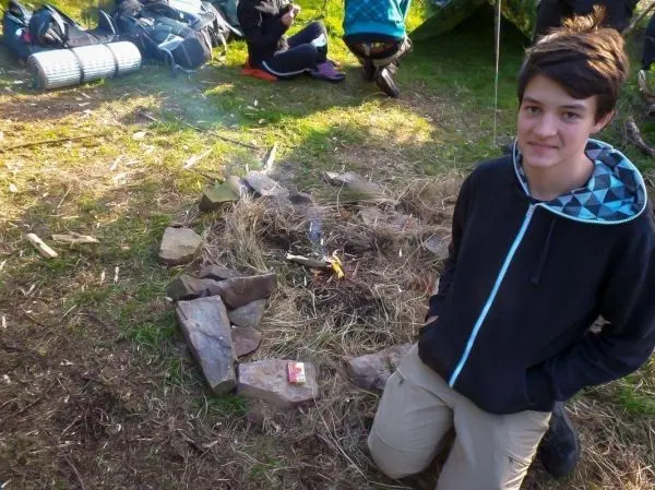 Kleines Bodenfeuer in einem Steinkreis, Zunder und Holz sichtbar