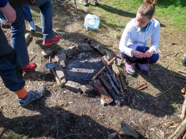 Kreis aus Steinen um eine Aschestelle, daneben Holz für ein Feuer