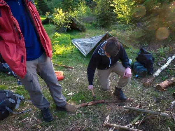 Messer bearbeitet Holzstück auf dem Boden in einem Waldgebiet