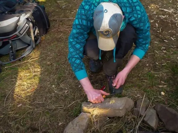 Messer schneidet Zunder auf einem Stein im Freien