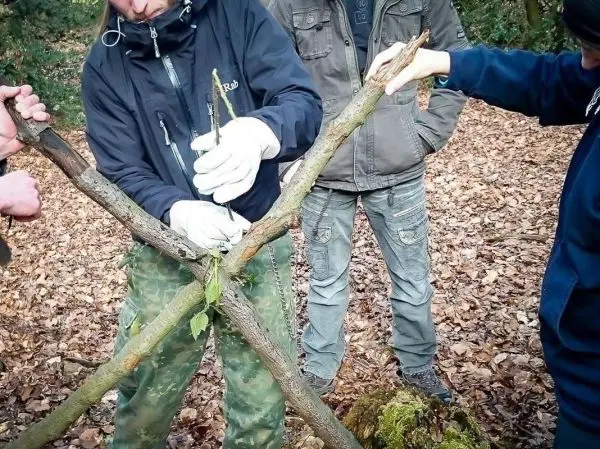 Person bindet Äste zu einer Konstruktion zusammen