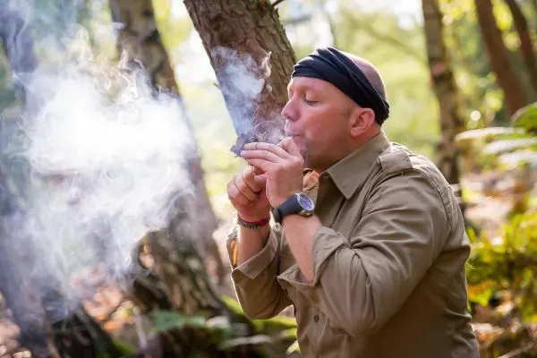 Kleinere Rauchwolken entstehen beim Anzünden von Zunder im Wald