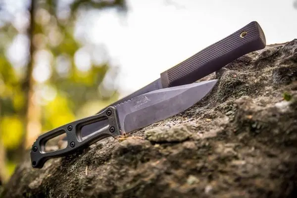 Zwei Messer liegen auf einem Stein im Wald