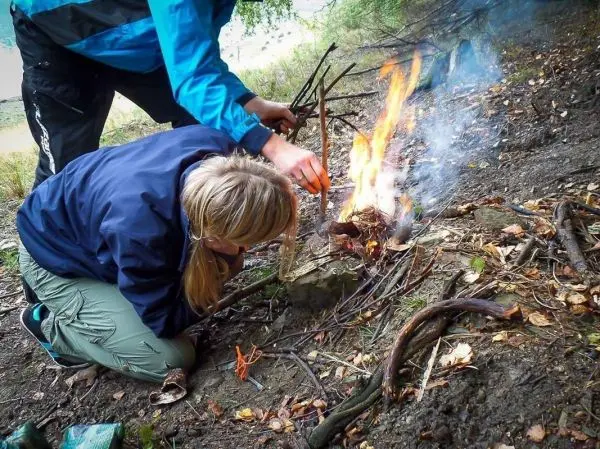 Kleine Flamme brennt aus Zunder und Ästen auf dem Boden