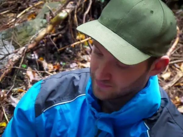 Person trägt eine grüne Mütze und blaue Jacke