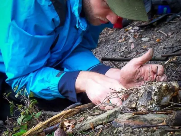 Zunder wird mit zwei Händen bearbeitet, um Funken zu erzeugen