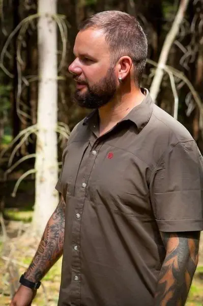 Ein Mann steht im Wald zwischen Bäumen