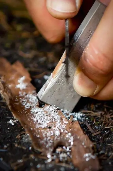 Feuerstahl erzeugt Funken auf Zunderstück aus Rinde