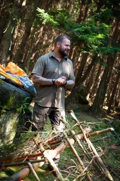 Lager mit Holzstruktur und Ausrüstung auf dem Boden im Wald