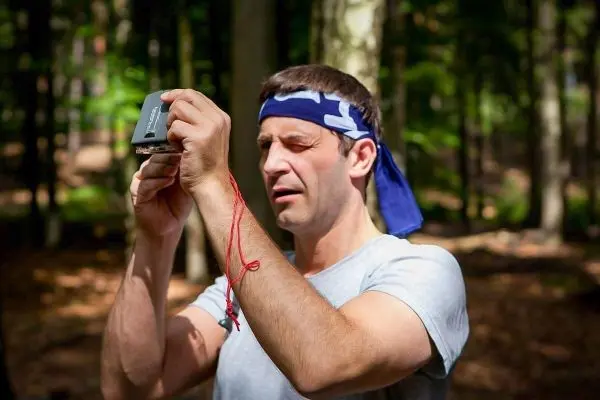 Mann hält ein Gerät in der Hand und schaut konzentriert darauf