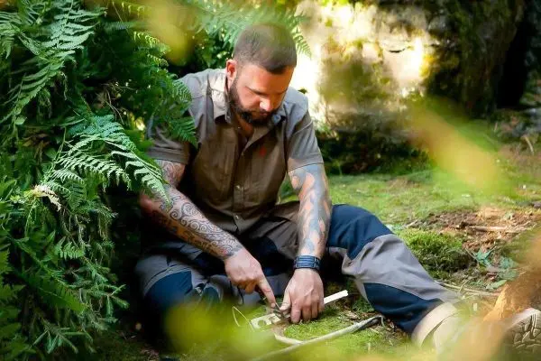 Messer bearbeitet Holzstück auf dem Boden im Wald