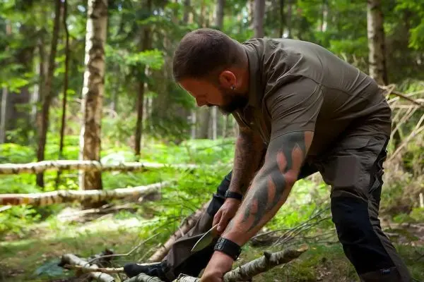 Messer schneidet Holzstück im Wald