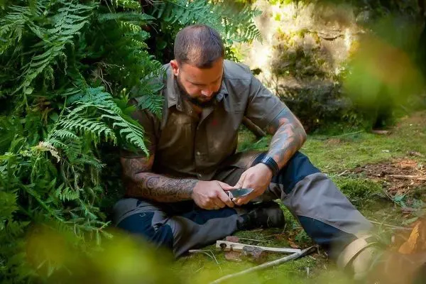 Messer wird zur Bearbeitung eines Holzstücks verwendet, um eine Kerbe zu erstellen