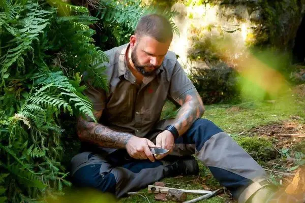 Messer wird zur Bearbeitung eines Holzstücks verwendet, um eine Kerbe zu schneiden