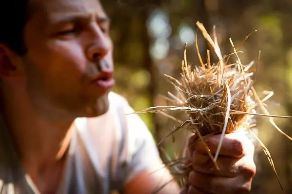 Zunder wird angeblasen, um Glut zu erzeugen