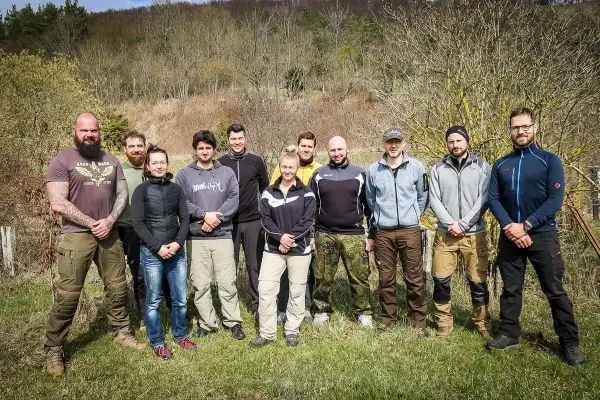 Gruppierung von zehn Personen in einer natürlichen Umgebung, stehen auf einer Wiese