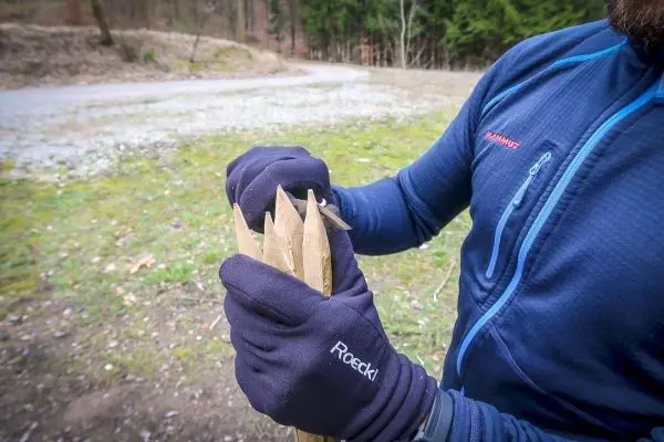 Person hält mehrere spitze Holzstücke in der Hand