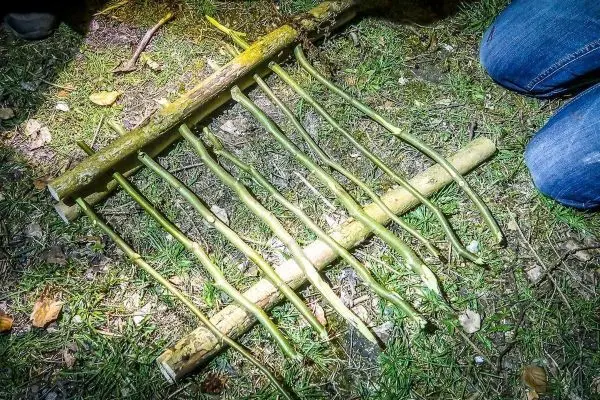 Selbstgebaute Falle aus Ästen liegt auf dem Boden