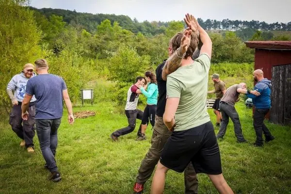 Gruppen üben Selbstverteidigungstechniken in einer grünen Wiese