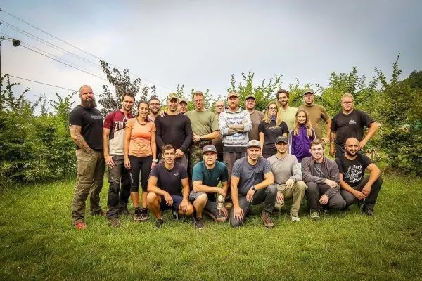 Gruppierung von Teilnehmern in Outdoor-Bekleidung auf einer Wiese