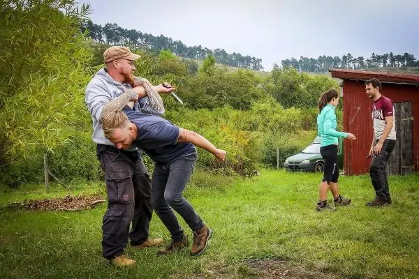 Kampftraining mit einem Angreifer und einem Verteidiger in einer grünen Umgebung
