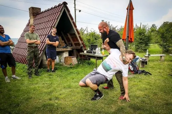 Kampftraining mit einem Teilnehmer, der von einem Trainer gehalten wird