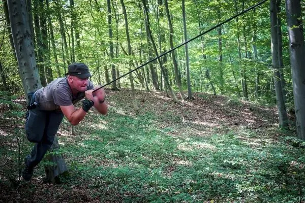 Person schwingt an einem Seil durch den Wald beim Survival Training