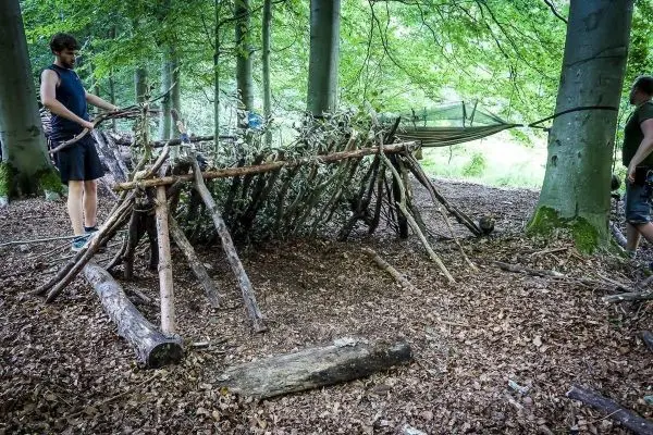 Selbstgebaute Notunterkunft aus Ästen und Blättern im Wald