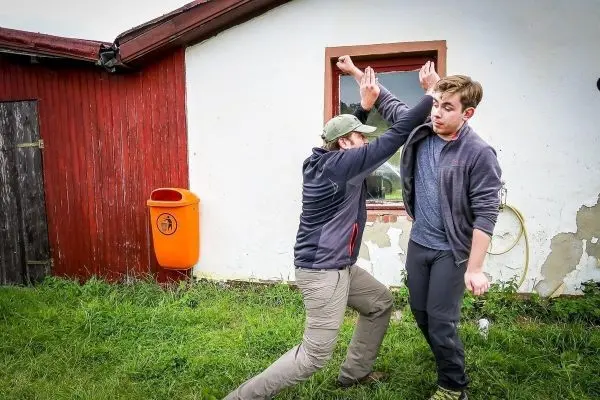 Zwei Personen üben eine Selbstverteidigungstechnik im Freien