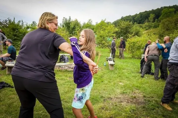 Zwei Personen üben eine Selbstverteidigungstechnik im Freien mit einem Stock