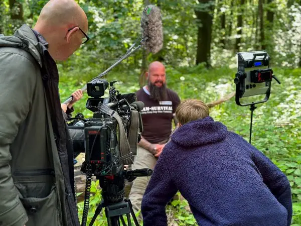 Kamera und Mikrofon erfassen Interview in bewaldeter Umgebung