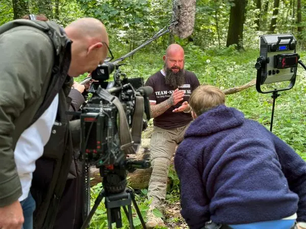 Kamera und Mikrofon erfassen Interview in bewaldeter Umgebung