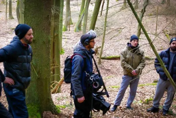 Gruppendiskussion im Wald mit Kamera- und Audioausrüstung