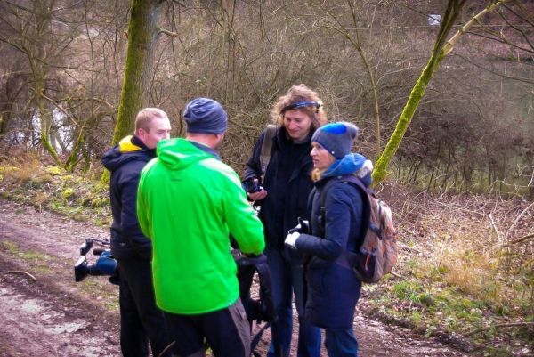 Vier Personen stehen auf einem Waldweg und diskutieren miteinander