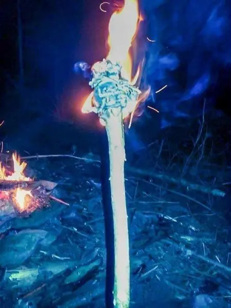 Brennt ein improvisierter Fackelstock mit Zunder und Flamme