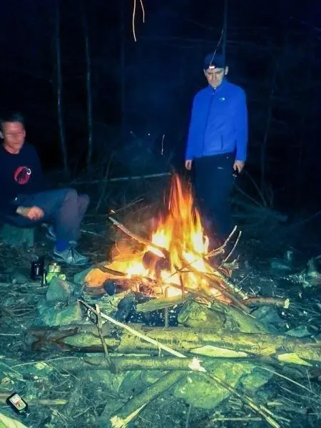 Kleine Flamme brennt zwischen Holzstücken im Wald